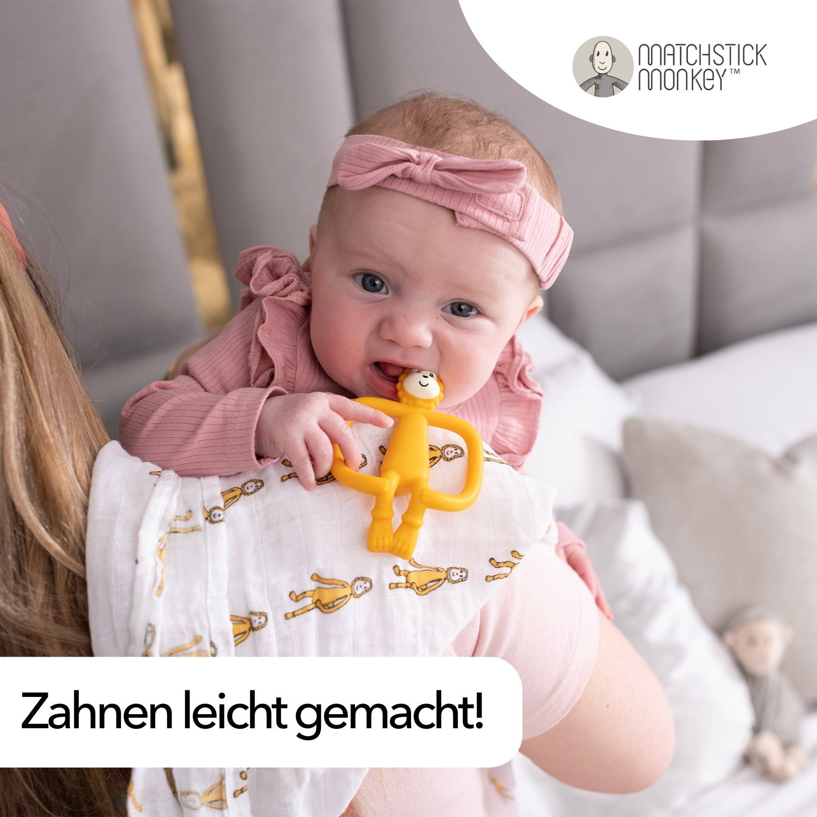 Baby, das von einer Frau gehalten wird, kaut auf einem gelben Affen-Beißring. Text: 'Zahnen leicht gemacht!'