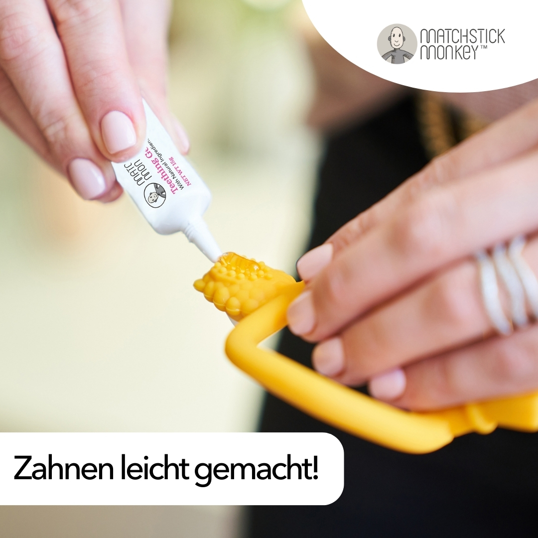 Hände tragen Gel auf gelben Beißring auf. Text: Zahnen leicht gemacht!