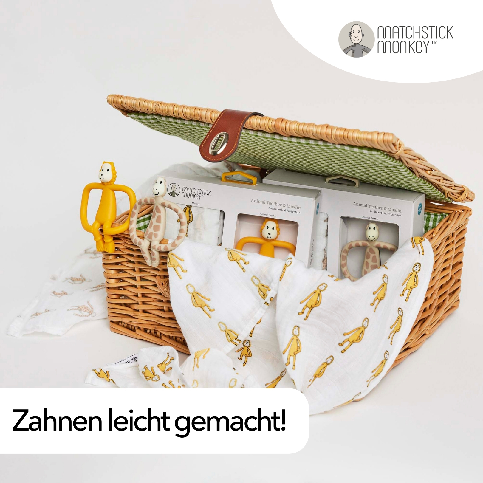 Ein Weidenkorb mit Babyartikeln, darunter Beißspielzeug und ein Musselintuch.