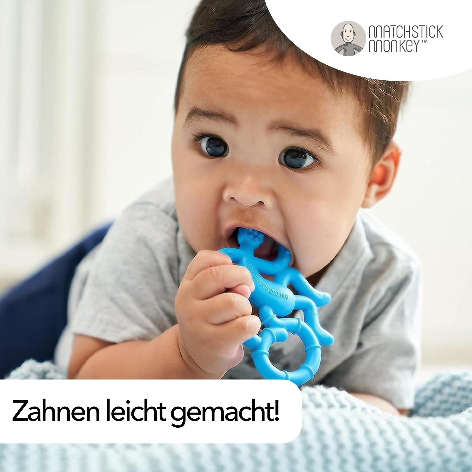Baby mit blauem Affenbeißring im Mund. Text: Zahnen leicht gemacht! Baby auf dem Bauch, schaut in die Kamera.