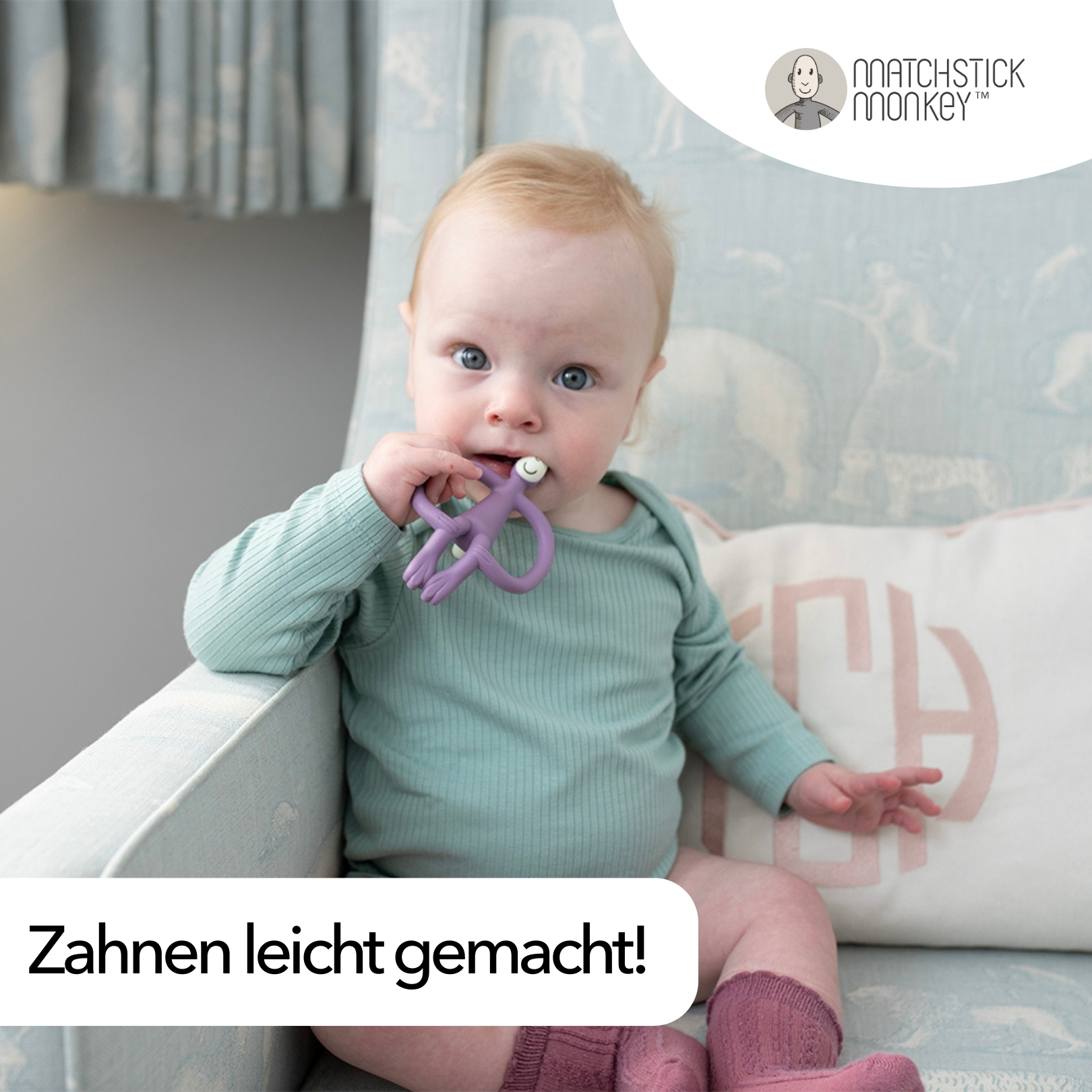Baby in blauem Strampler mit lila Beißring im Mund, sitzend. Text: Zahnen leicht gemacht! Matchstick Monkey Logo.