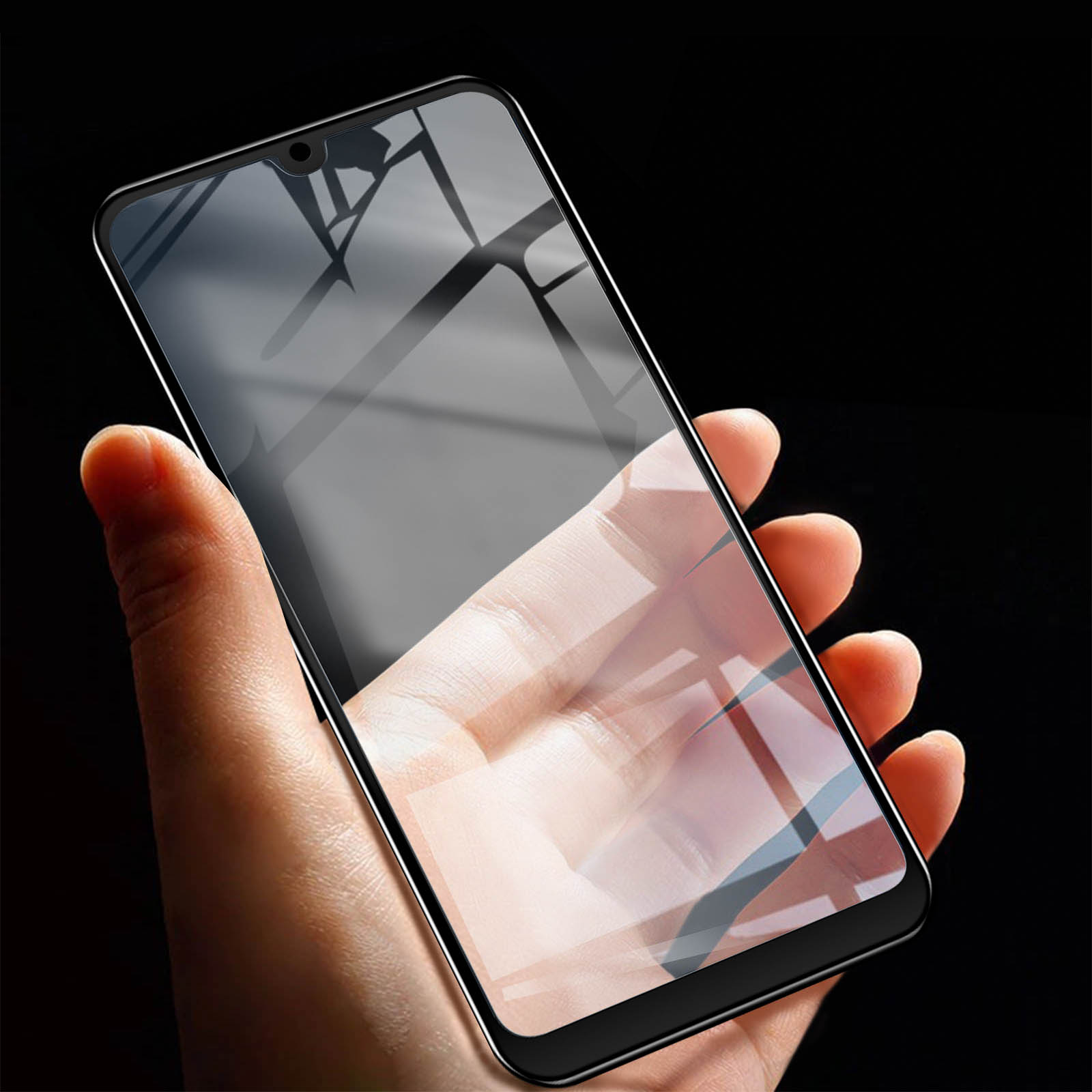 Mano che tiene un telefono con una protezione schermo applicata. La protezione è scura.