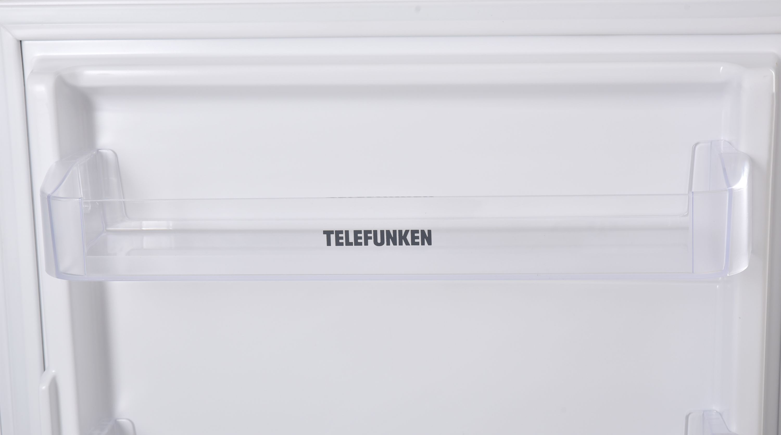 Weißer Kühlschrankinnenraum mit transparentem Kunststoffregal, schwarzer Schriftzug TELEFUNKEN.