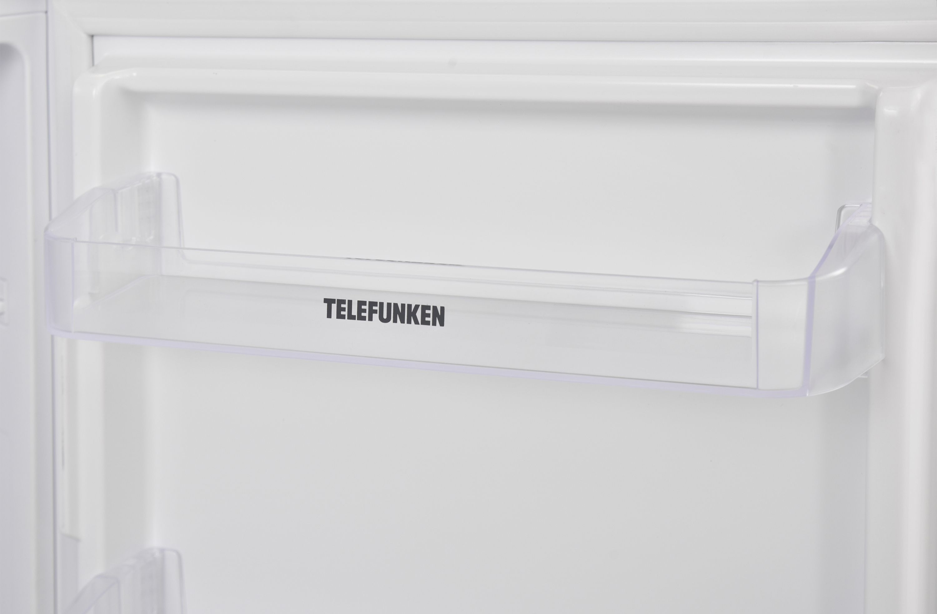 Weißer Kühlschrankinnenraum, transparentes Kunststoffregal mit schwarzem TELEFUNKEN-Schriftzug.