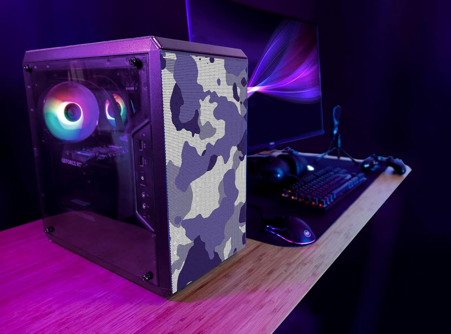 Konfiguracja komputera z obudową w kamuflażu, monitorem, klawiaturą i myszą na biurku.