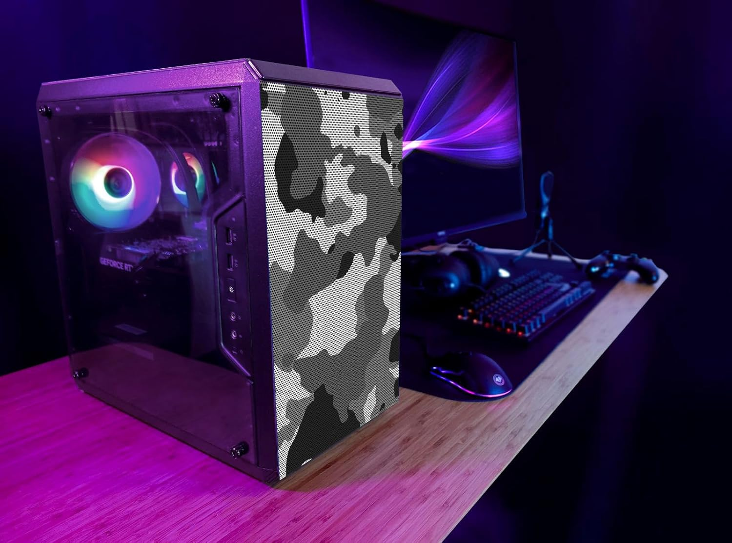 Konfiguracja komputera z obudową w kamuflażu, monitorem, klawiaturą i myszą na biurku.