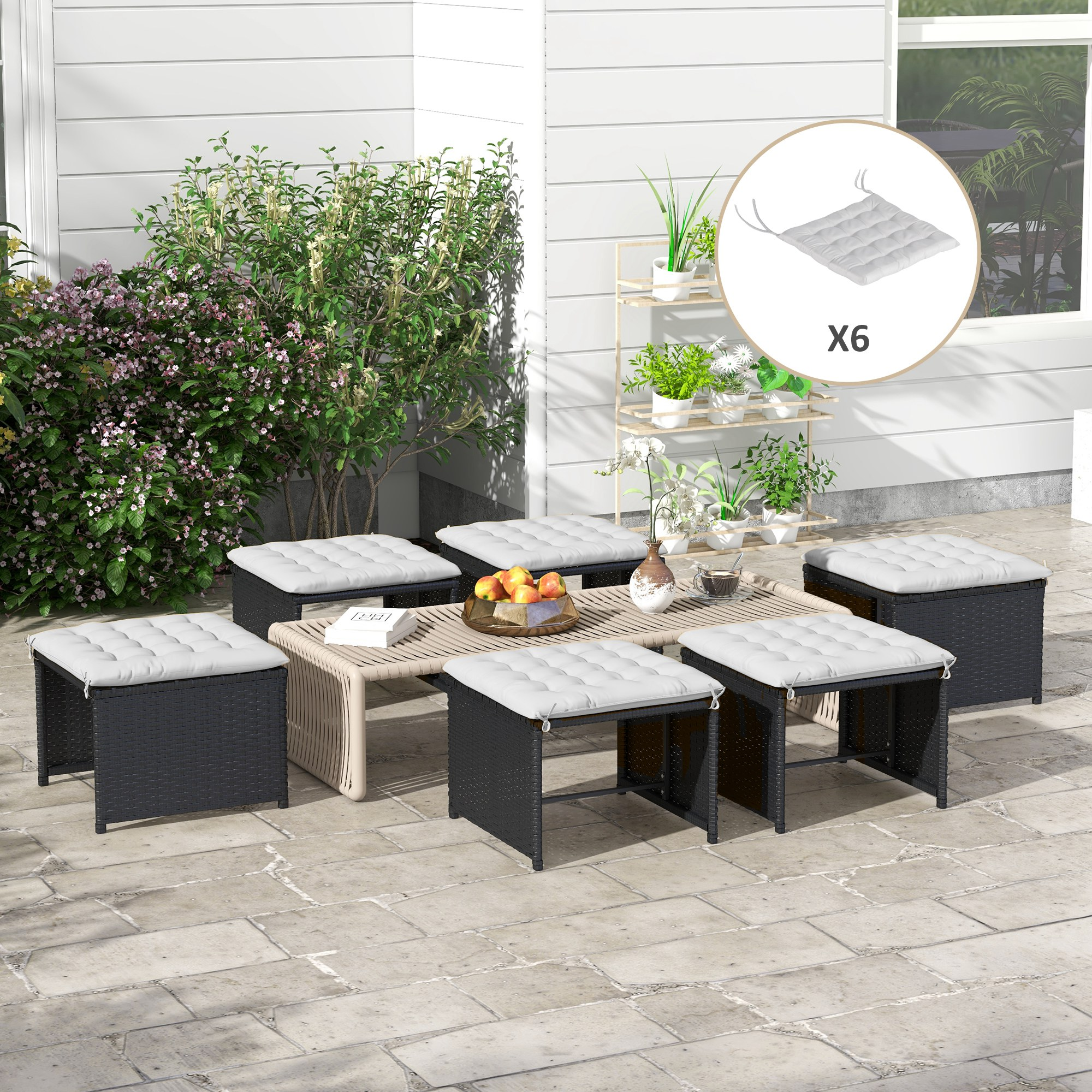 Outdoor-Sitzarrangement mit sechs schwarzen Korbstühlen und einem hellen Holztisch mit Kissen.