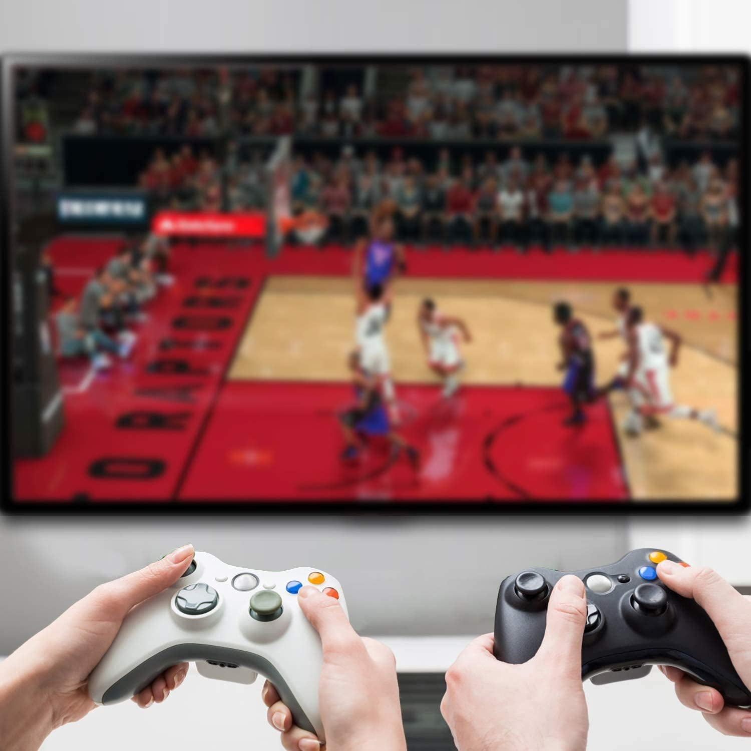 Hände halten Gamecontroller und spielen ein Spiel auf einem Fernseher. Das Spiel ist Basketball.
