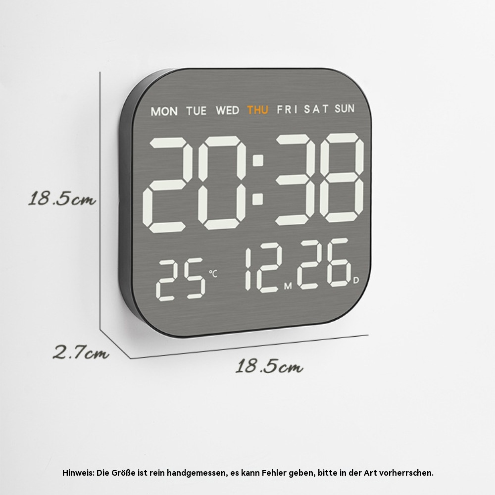 Nahaufnahme einer Digitaluhr, die Zeit, Datum und Tag anzeigt. Grauer Rahmen, weiße Ziffern. Messungen an den Seiten.