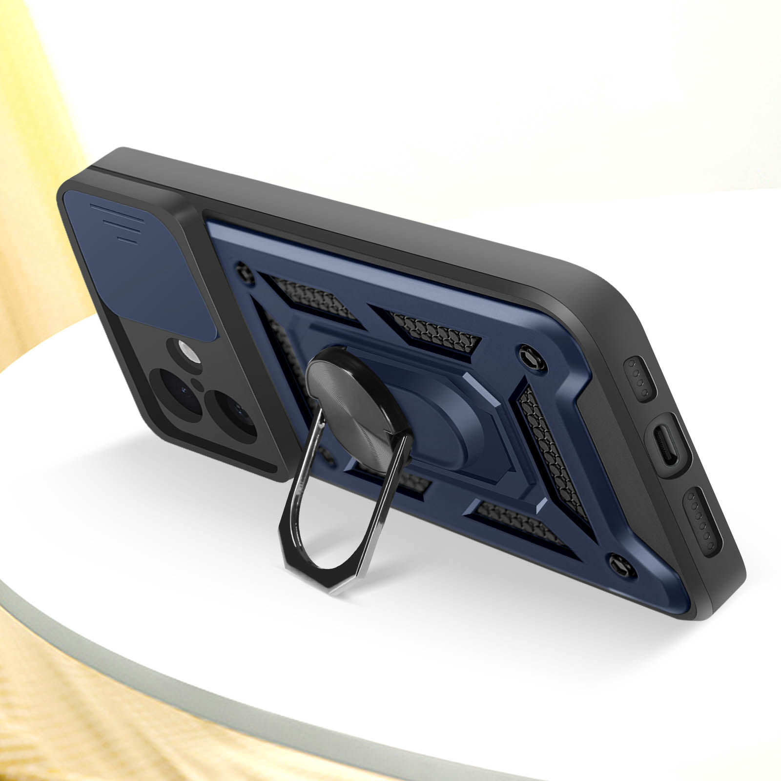Custodia nera per telefono con centro blu e supporto ad anello. È appoggiata su una superficie bianca.