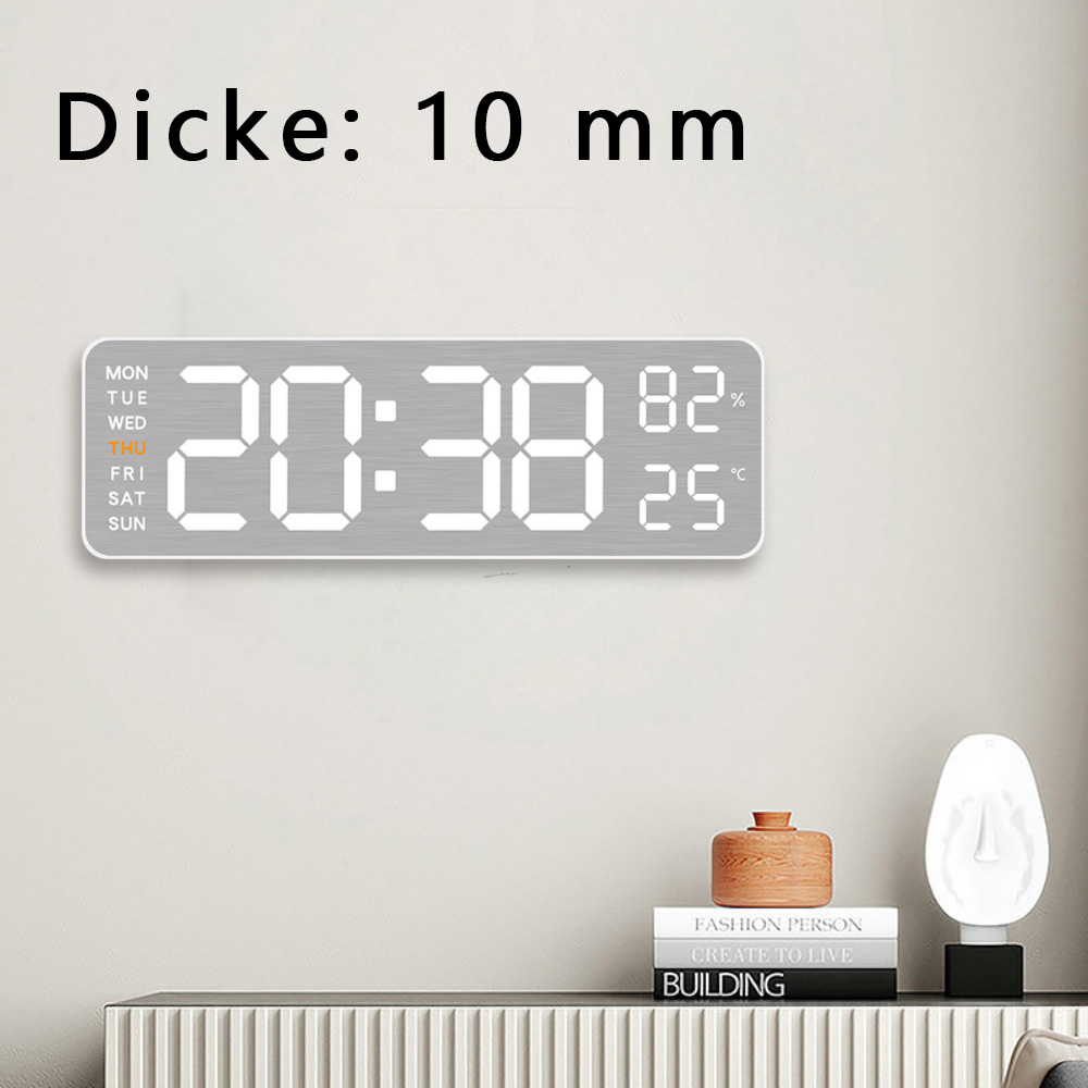 Digitaluhr an der Wand, zeigt 20:38, 82% und 25°C, mit Gegenständen darunter.