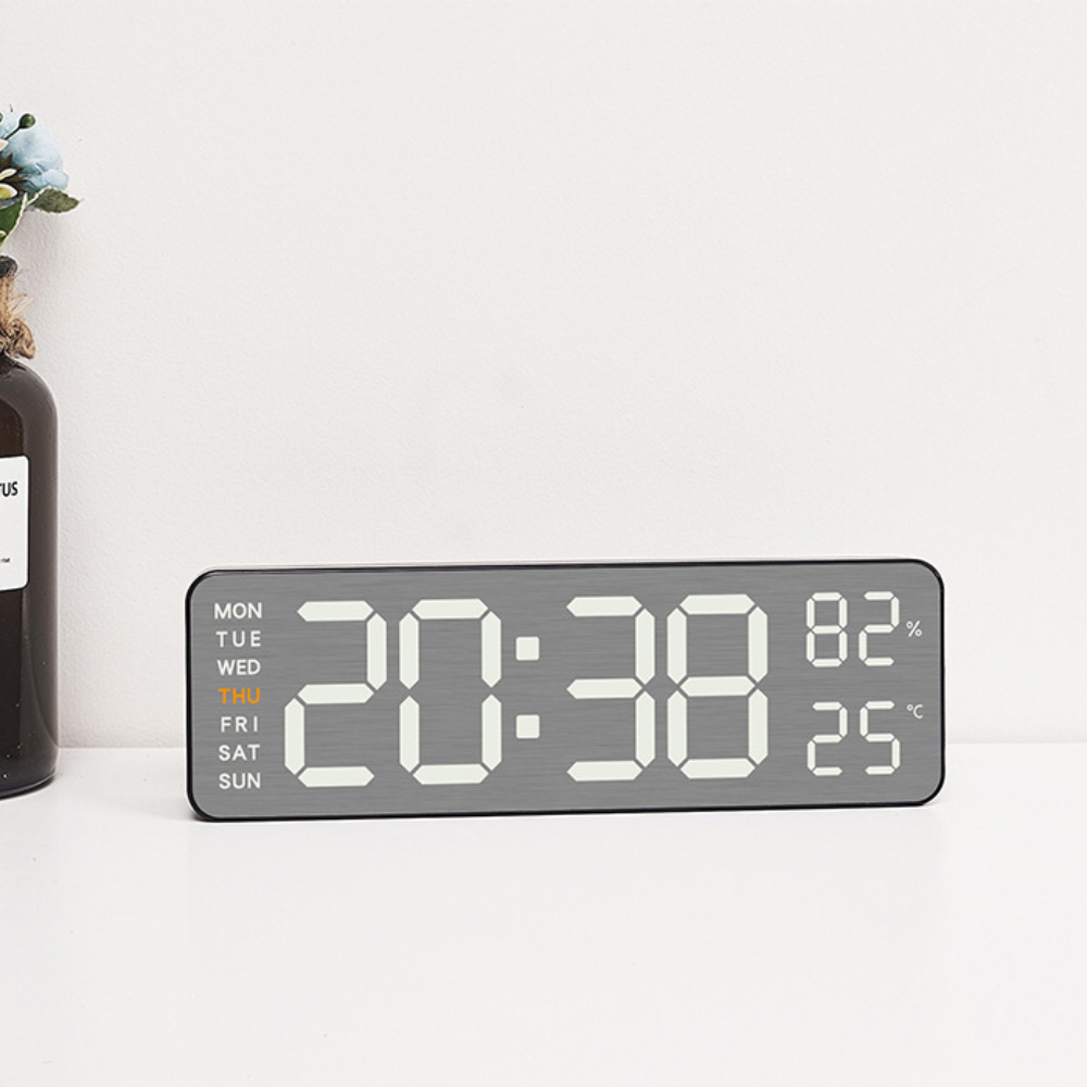 Digitaluhr mit Anzeige von Uhrzeit, Datum und Temperatur. Die Uhr ist grau mit weißen Ziffern.