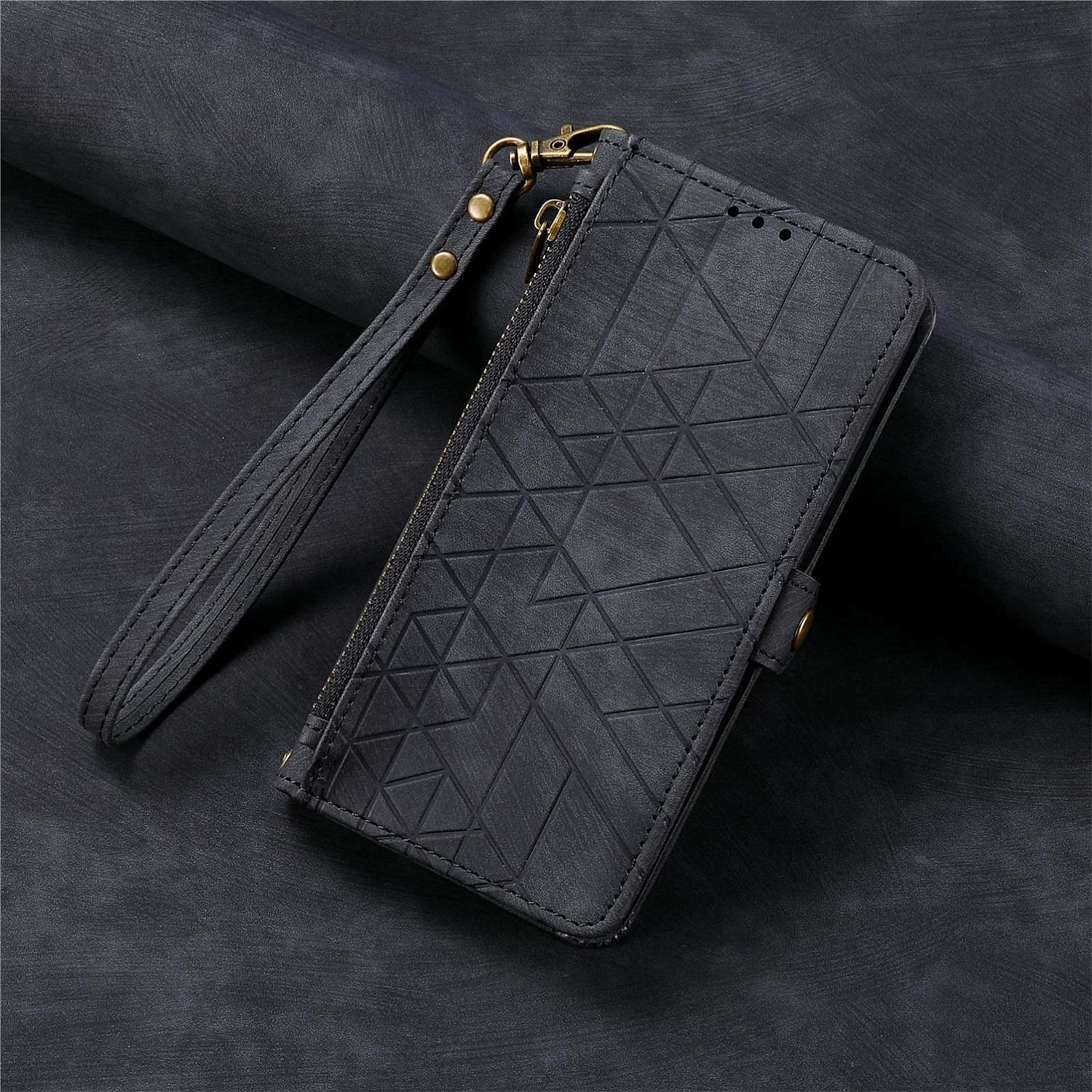 Eine schwarze Leder-Handyhülle mit geometrischem Design und Handschlaufe. Dunkler Hintergrund.