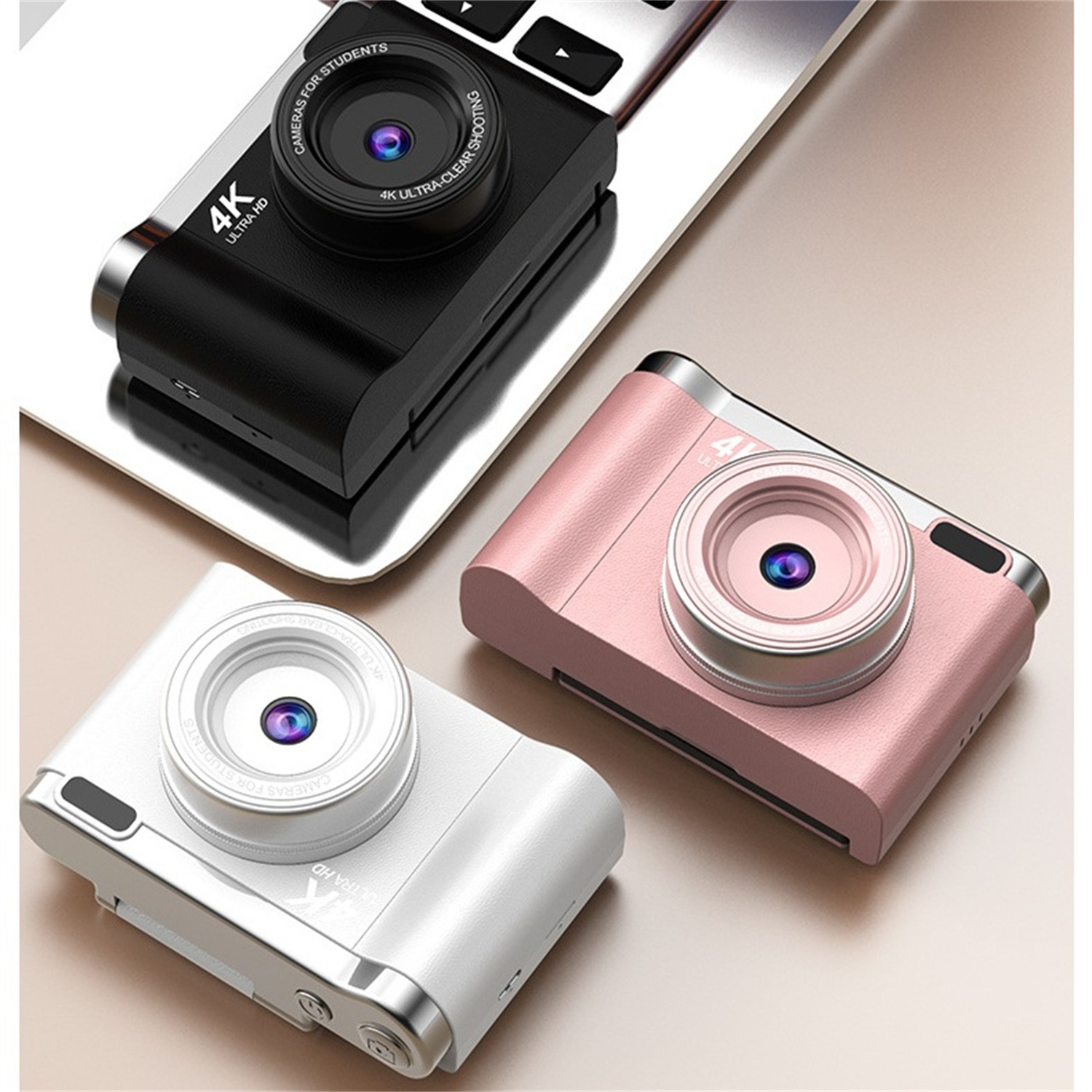 Drei Kameras, schwarz, rosa und weiß, auf einer hellen Oberfläche. 4K Ultra HD, für Studenten.