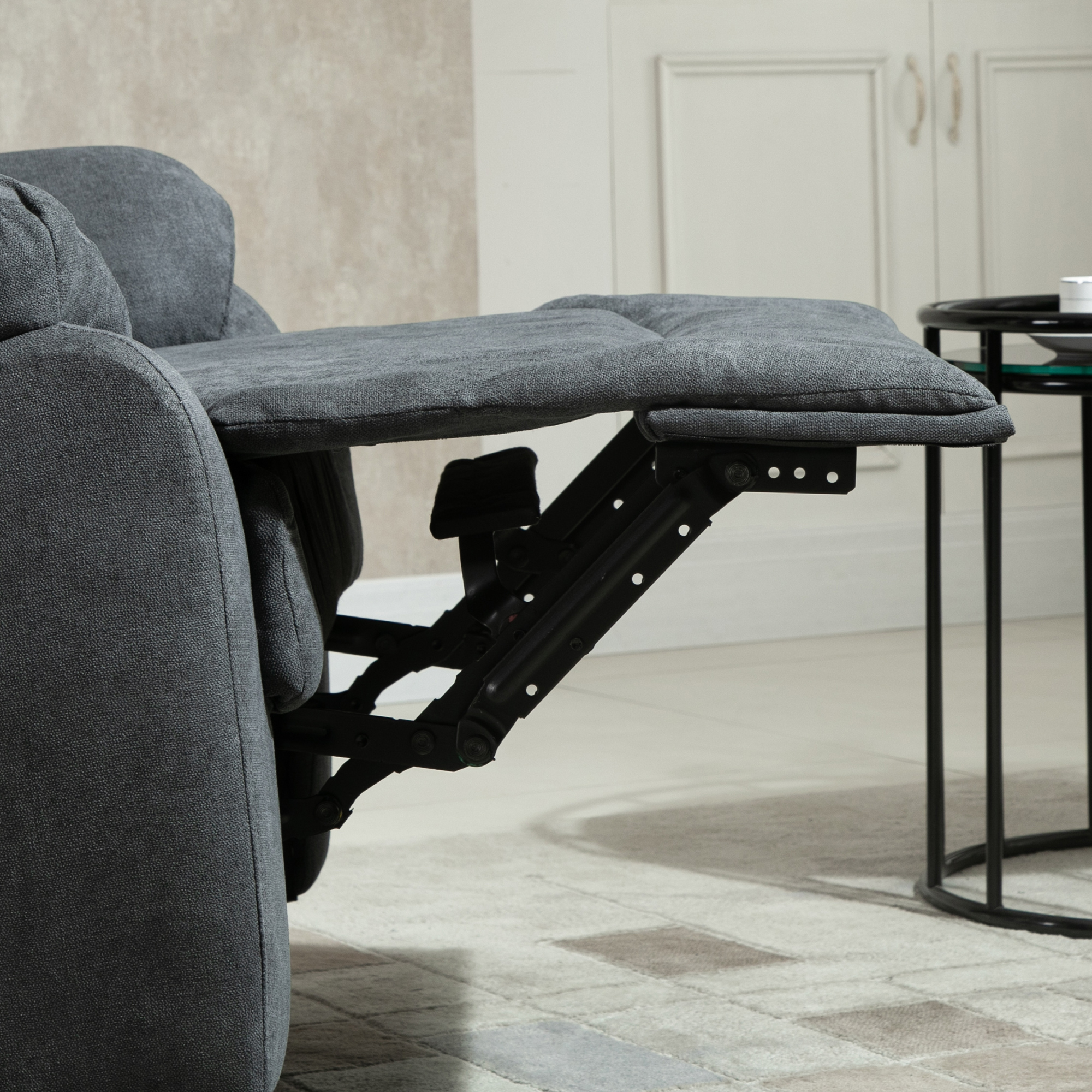 Ein Relaxsessel mit ausgeklappter Fußstütze, der Mechanismus und den grauen Stoff zeigend.