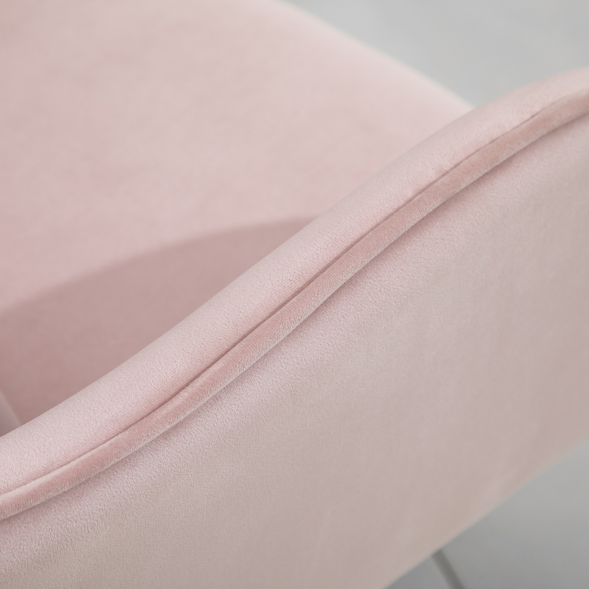 Nahaufnahme eines rosa Samtstuhls. Fokus auf die Textur des Stoffes.