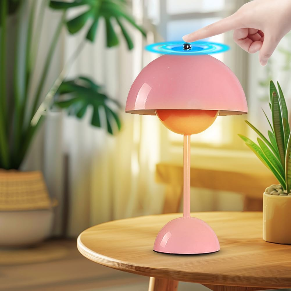 Rosa Lampe mit rotierendem Oberteil auf einem Tisch, Hand in der Nähe.