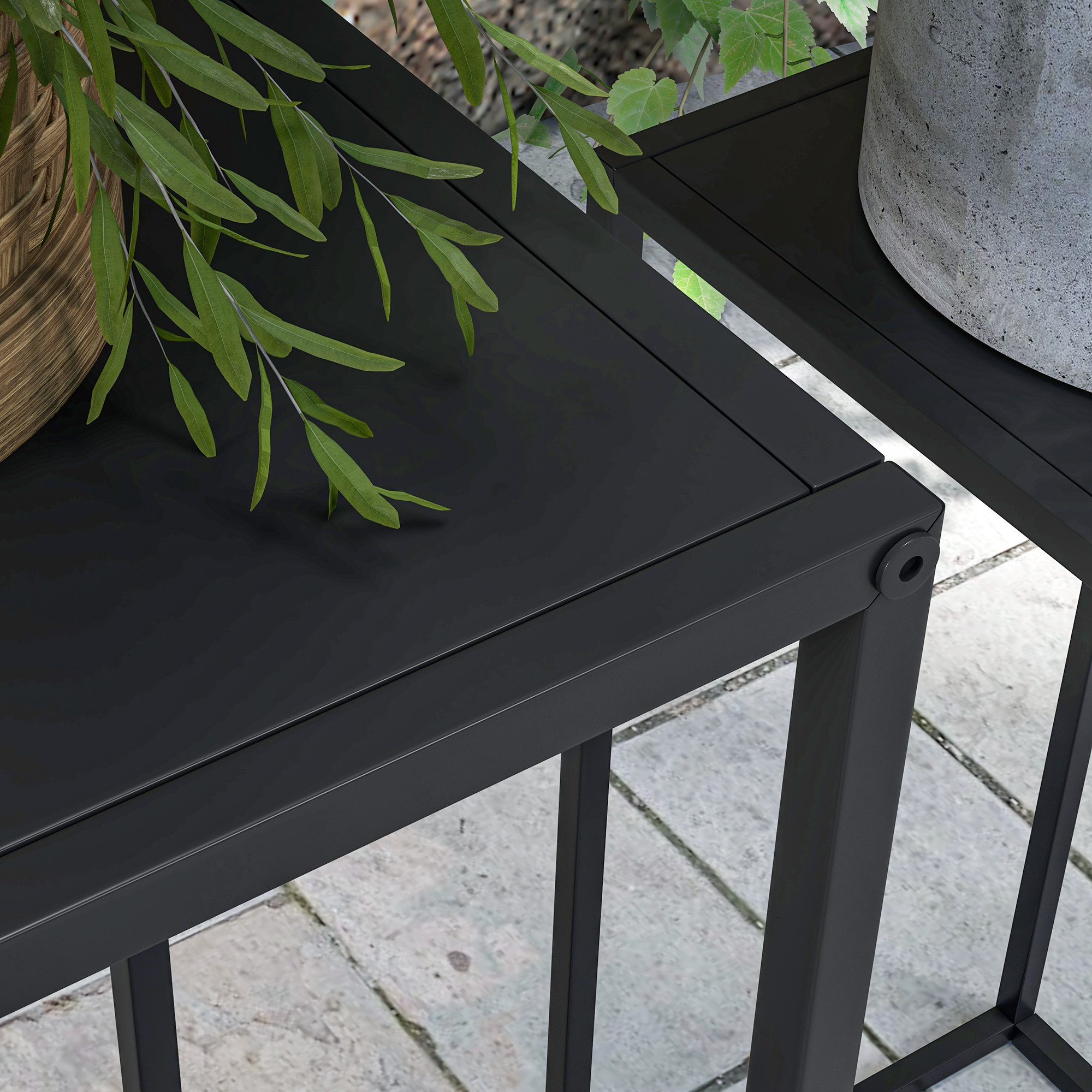 Primo piano di un piano del tavolo nero con piante verdi e un vaso.