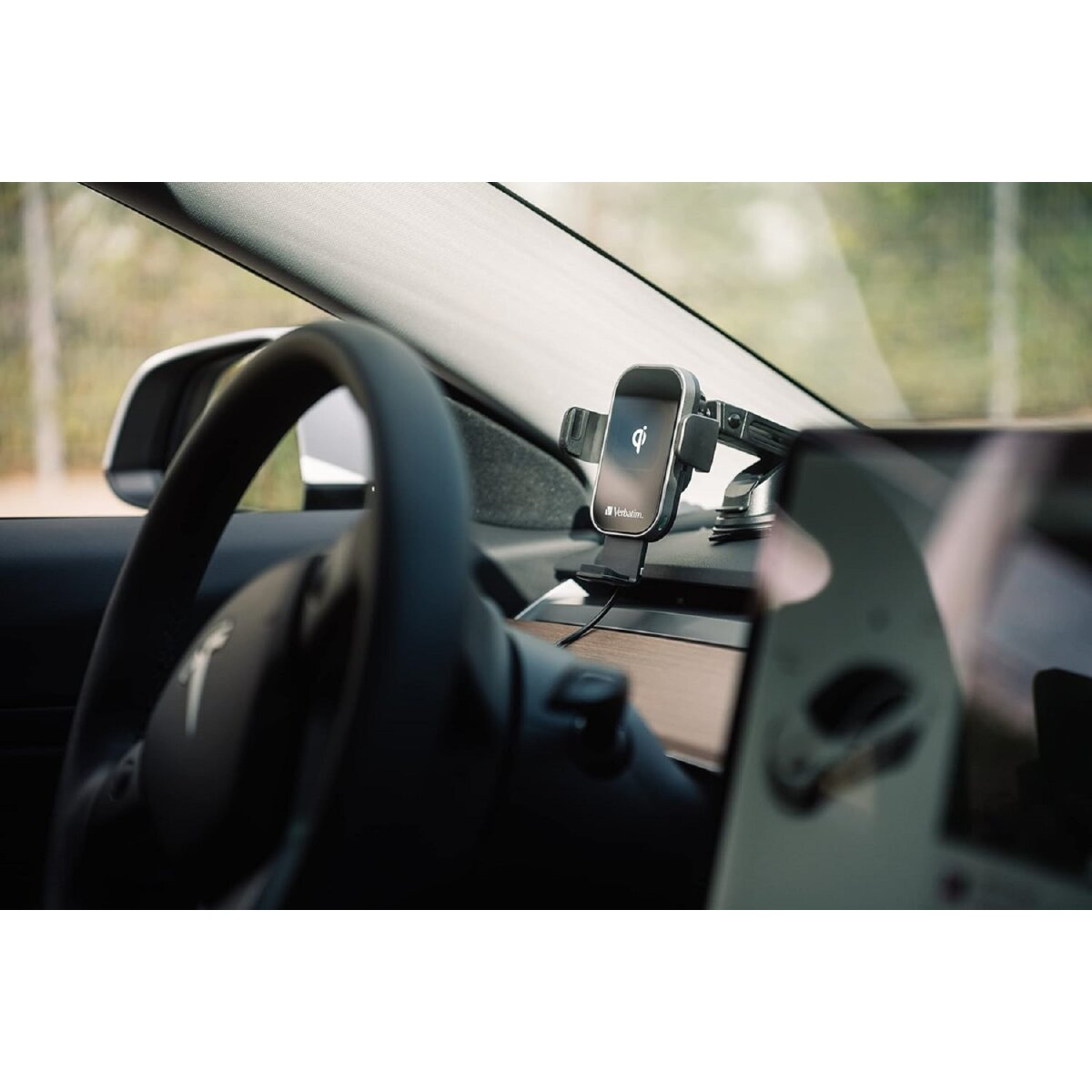Persona en un coche usando un teléfono conectado a un soporte para teléfono de coche.
