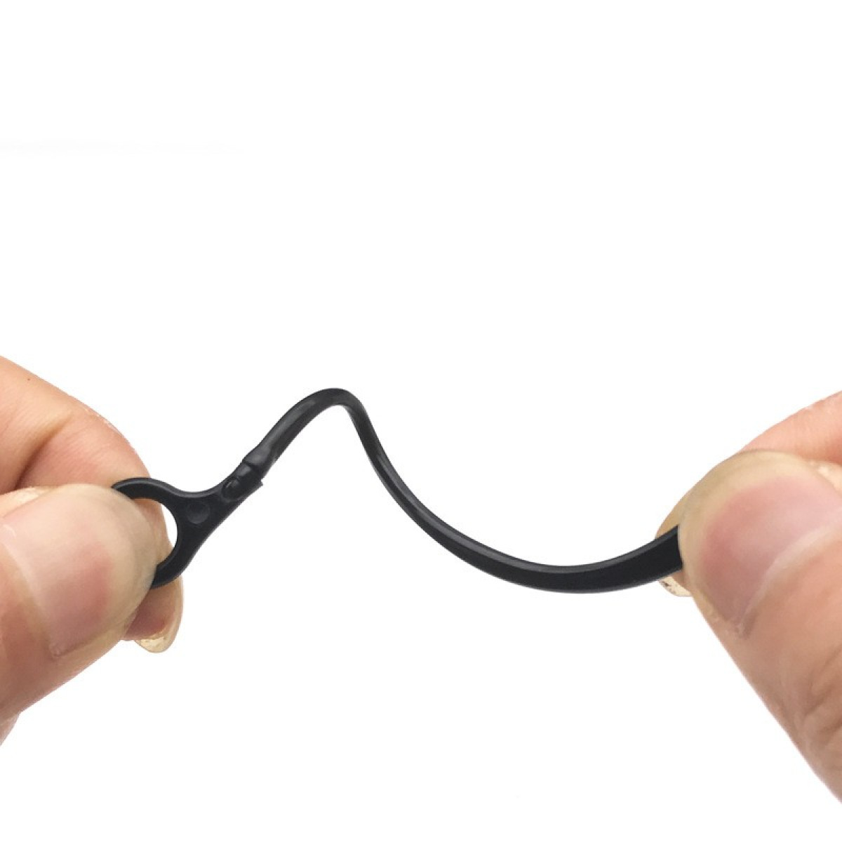 Zbliżenie dwóch dłoni trzymających czarny, zakrzywiony, plastikowy pasek z pętlą na końcu.