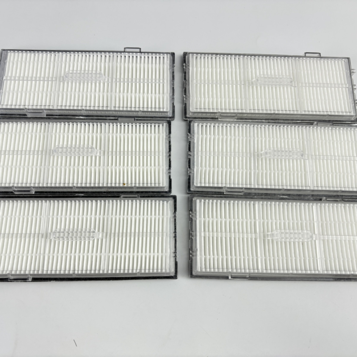 Zestaw sześciu białych filtrów w przezroczystej plastikowej obudowie, ułożonych w dwóch rzędach po trzy.