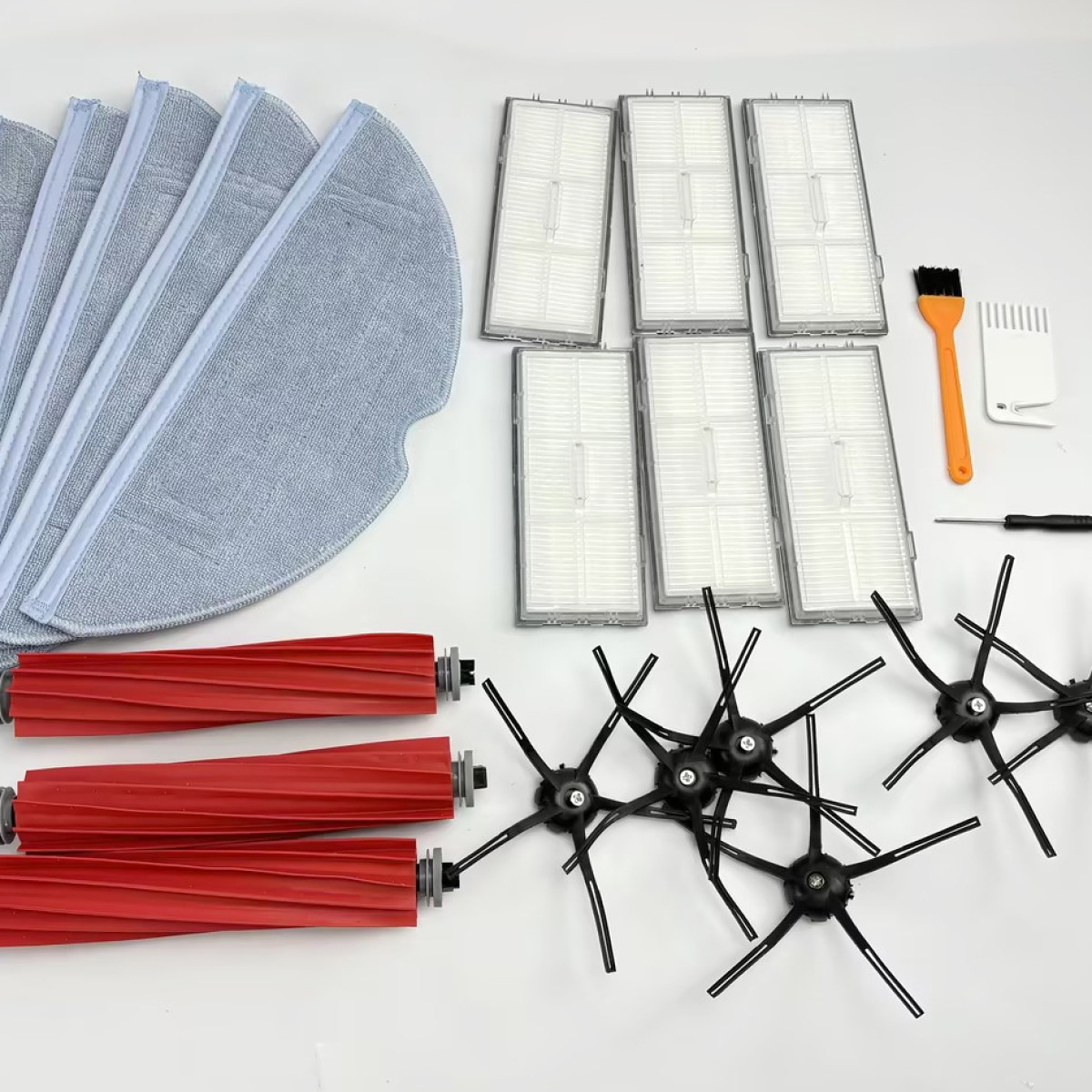 Akcesoria do odkurzacza: nakładki, filtry, szczotki i wałki. Wszystko jest białe, szare i czerwone.