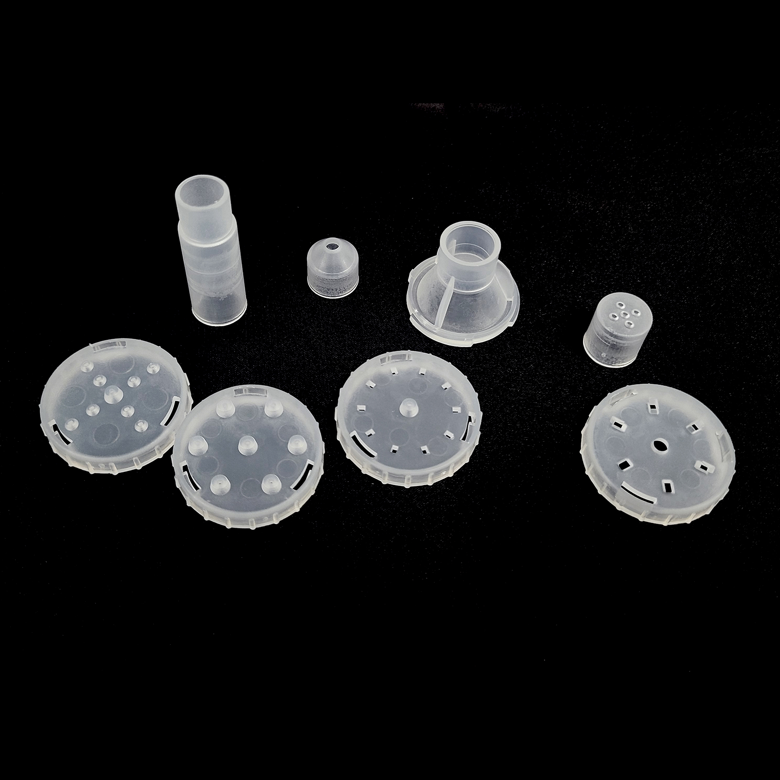 Różne przezroczyste elementy z tworzywa sztucznego na czarnej powierzchni.