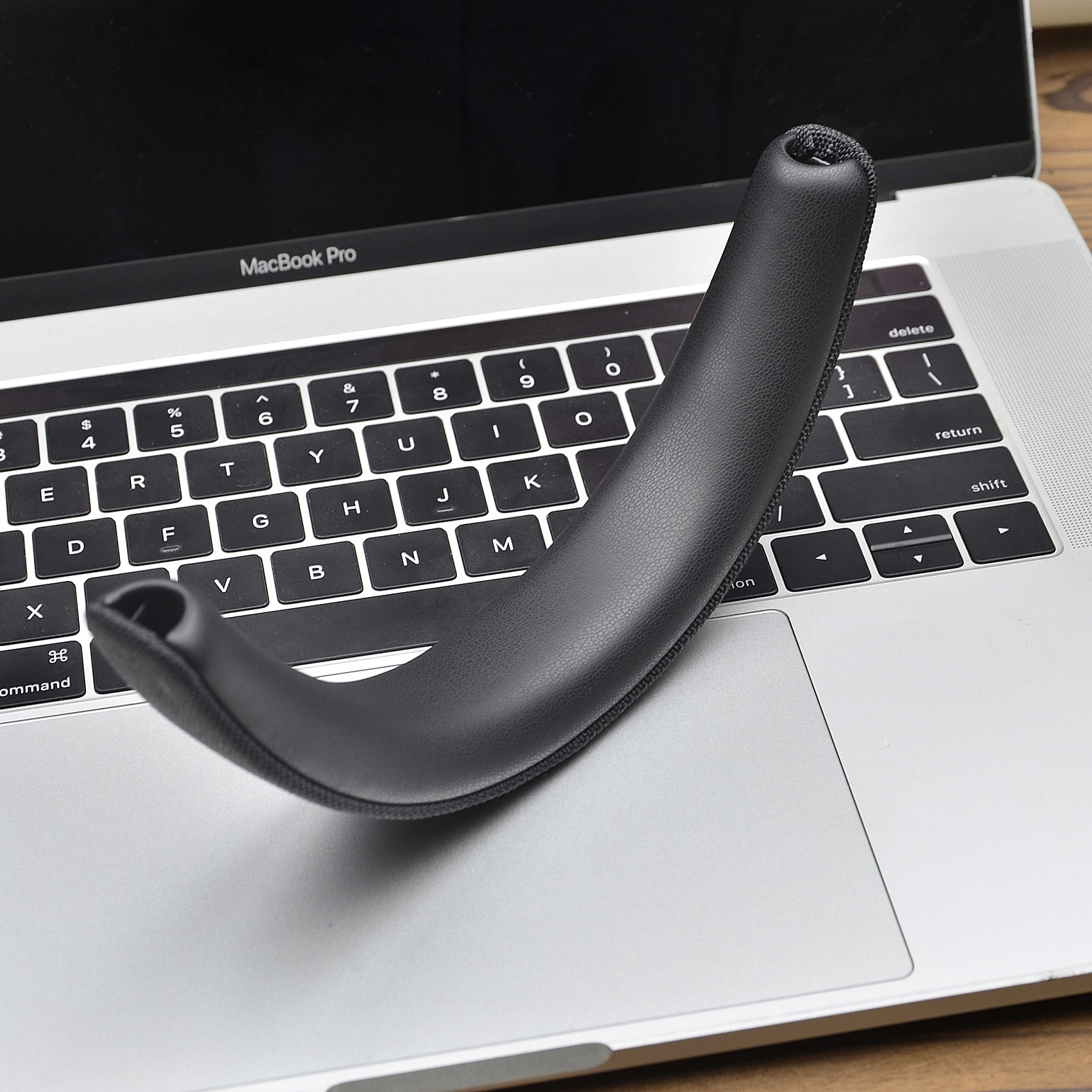 Czarna klawiatura laptopa z czarną poduszką na górze.