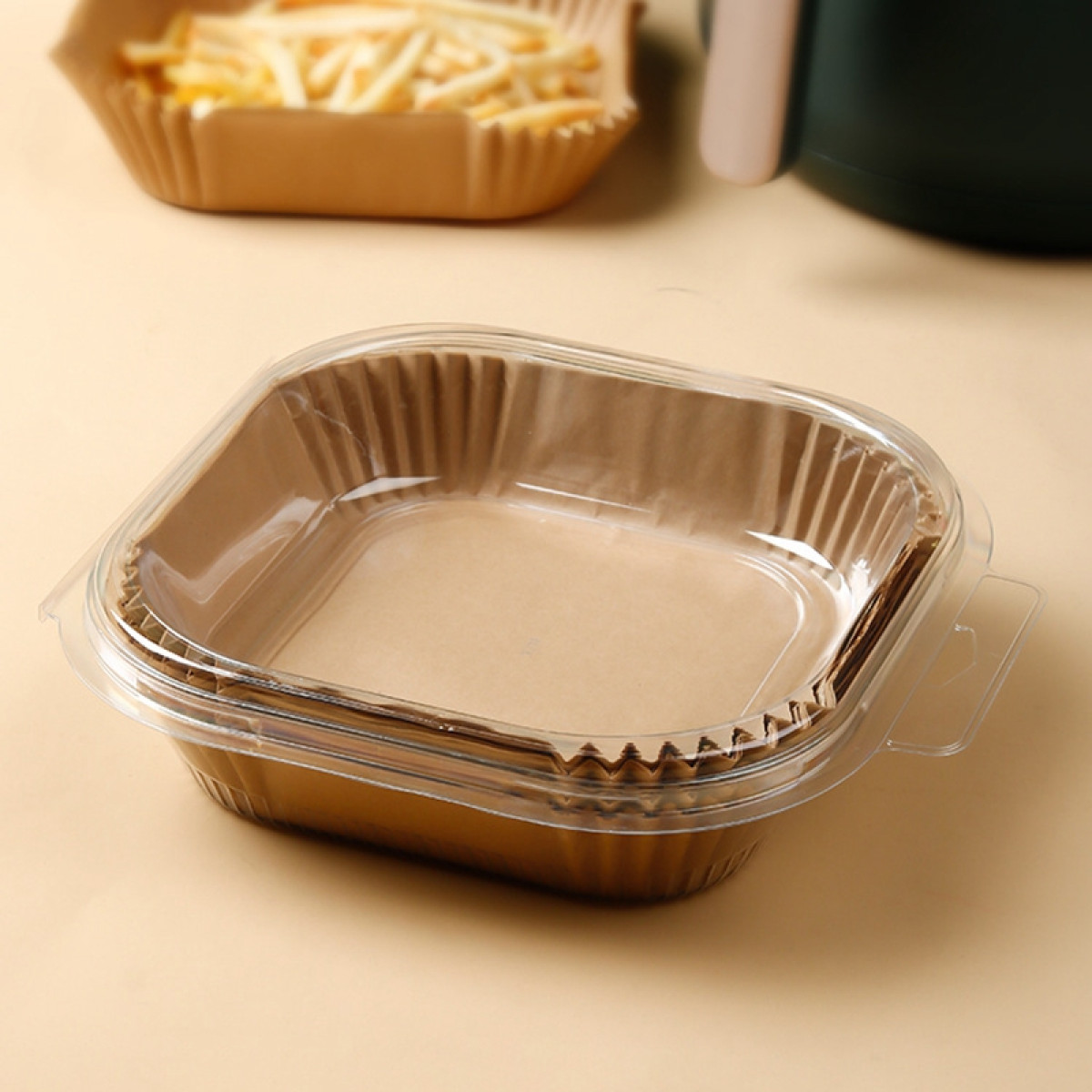 Brązowy papierowy pojemnik na żywność z przezroczystą plastikową pokrywką zawierającą produkt spożywczy.