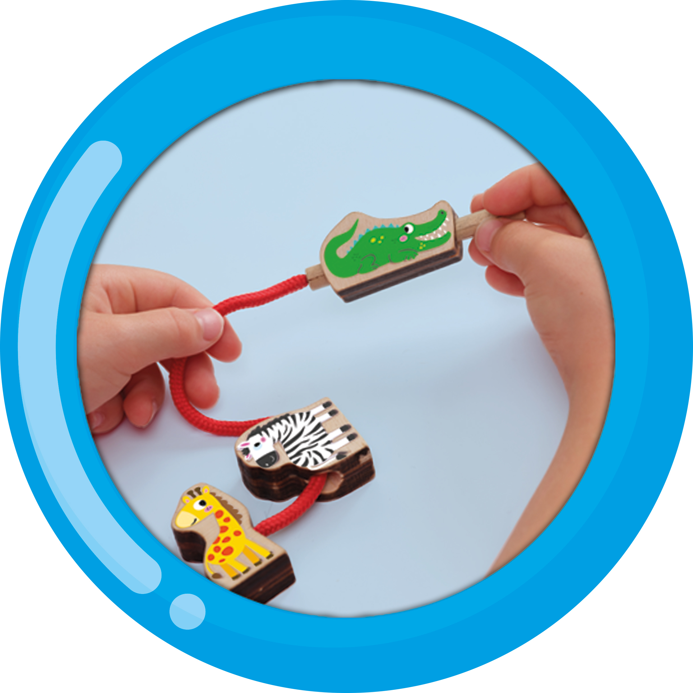 Hände spielen mit hölzernen Tierspielzeugen. Krokodil, Zebra und Giraffe sind durch eine rote Schnur verbunden.