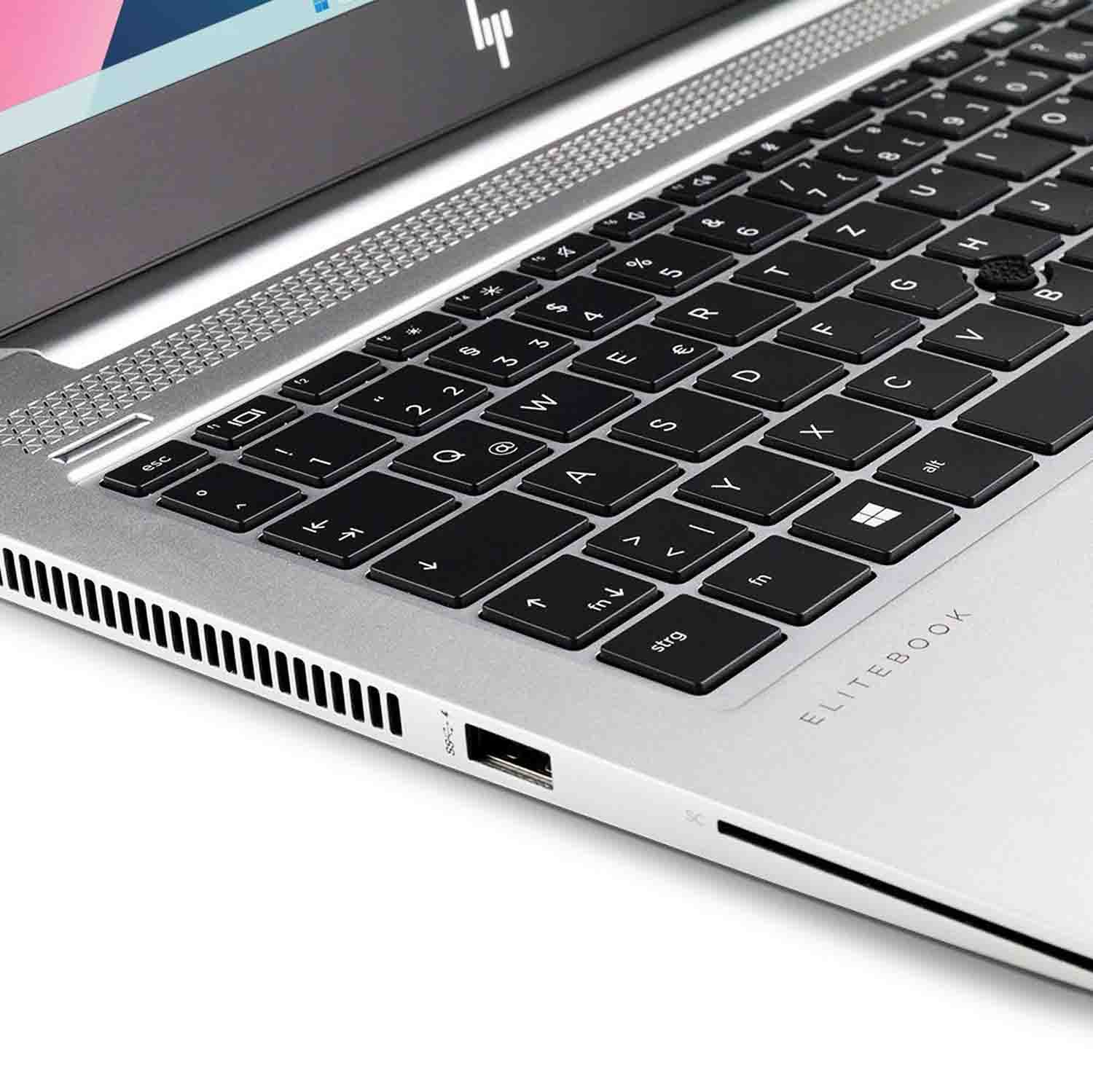 Primer plano de un teclado de portátil plateado, con teclas negras y el logotipo 'Elitebook'.