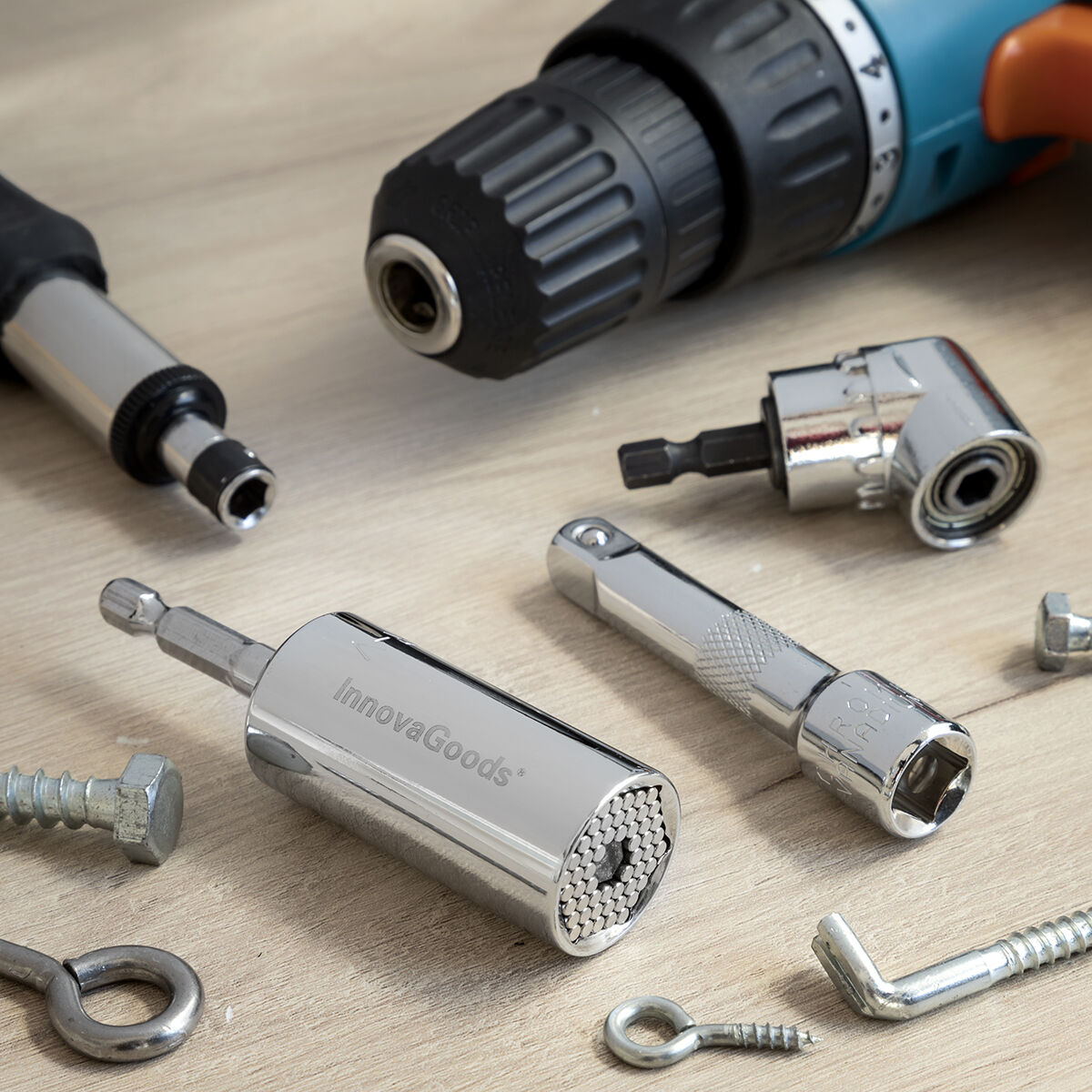 Werkzeuge: Bohrmaschine, Steckdosenadapter und Schrauben auf Holzoberfläche, Nahaufnahme.