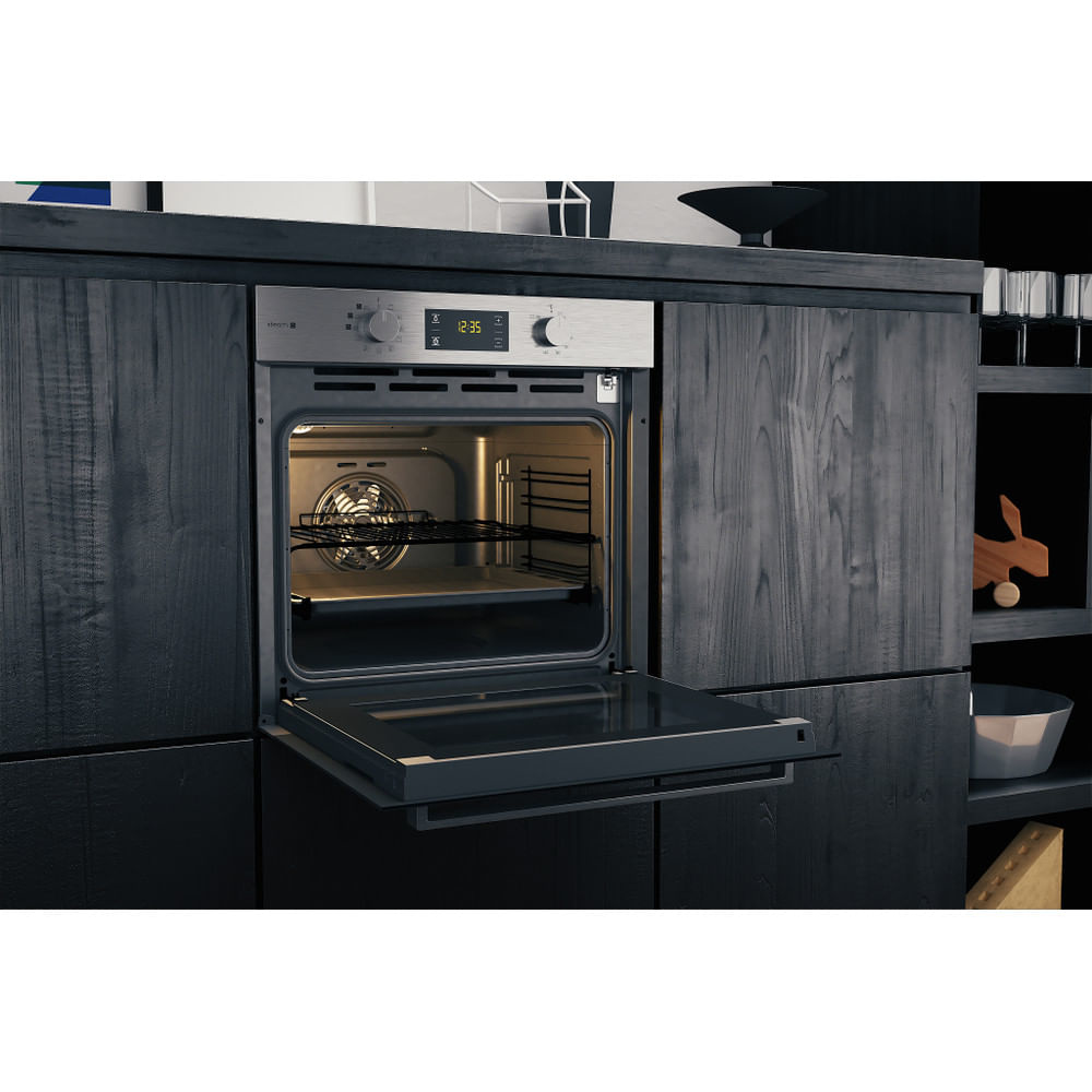 Un forno in un ambiente cucina, aperto, con luci interne accese, mostra una ventola e ripiani.