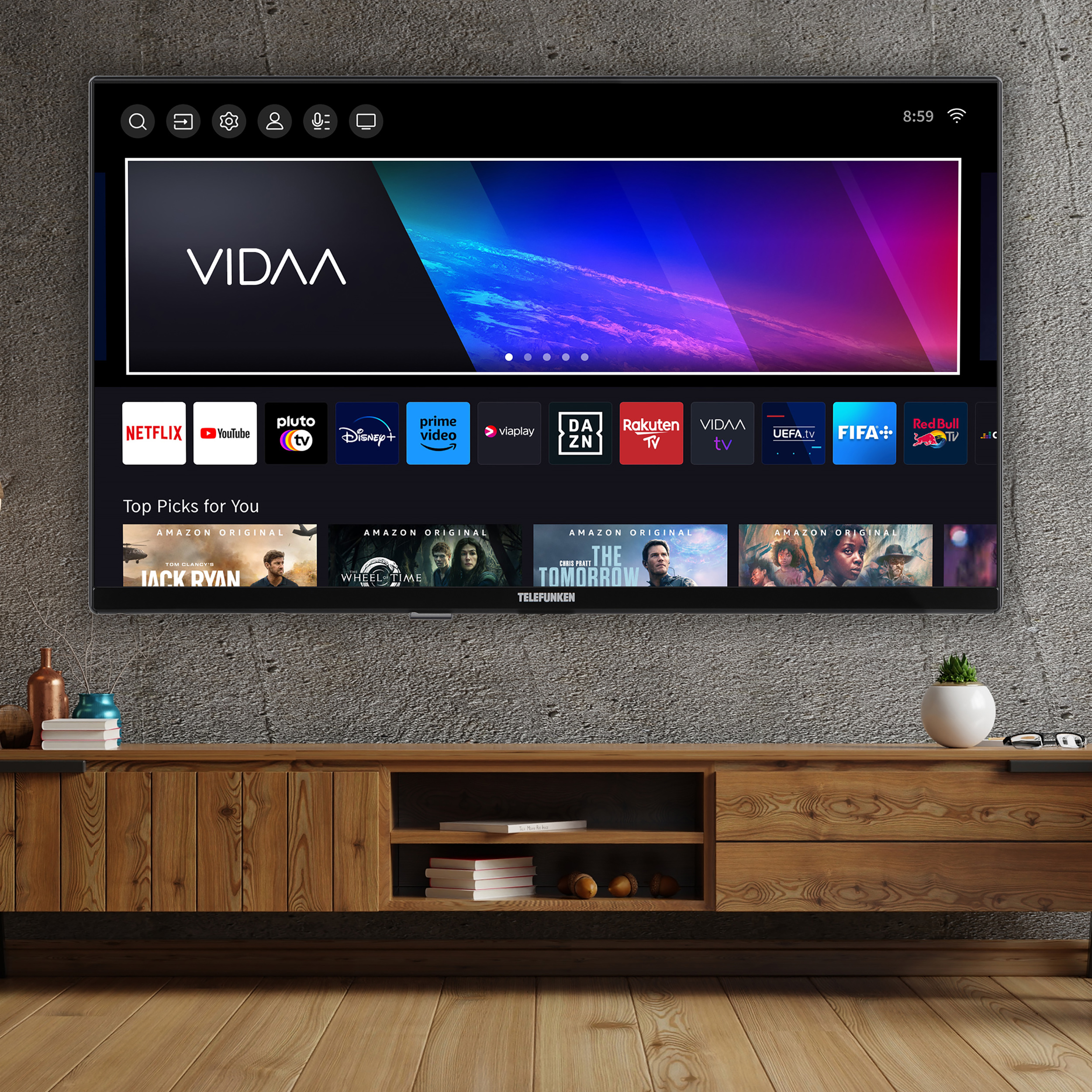 Ein Fernseher zeigt das VIDAA-Logo und Apps auf dem Bildschirm. Er steht auf einem Holzschrank vor einer grauen Wand.