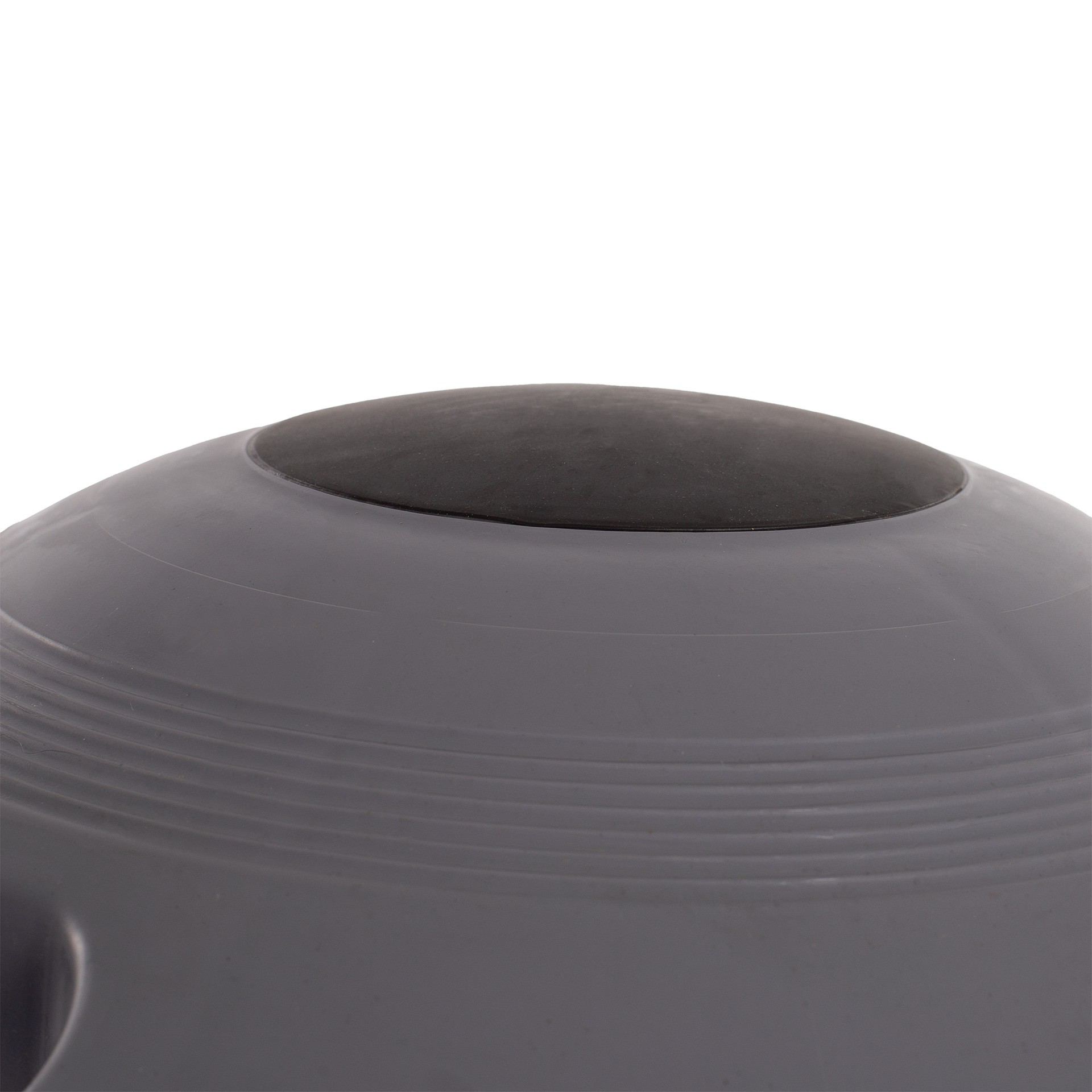 Primer plano de una pelota de ejercicio gris con parte superior circular negra. Fondo blanco.