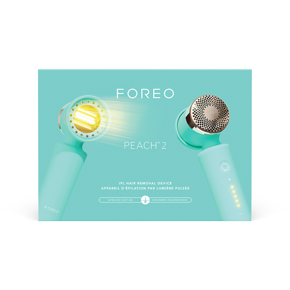 Divers articles Foreo : un appareil facial rose, un support transparent, une carte QR et un câble de chargement.