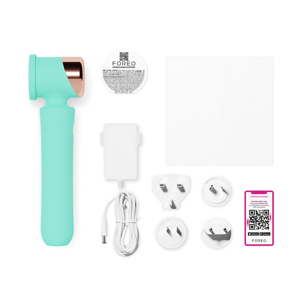 Un appareil Foreo turquoise et accessoires, dont des prises, un chargeur et un chiffon de nettoyage.