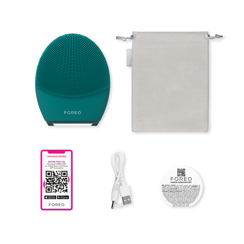Een teal Foreo gezichtsreinigingsapparaat met extra accessoires, waaronder een oplaadkabel en tas.