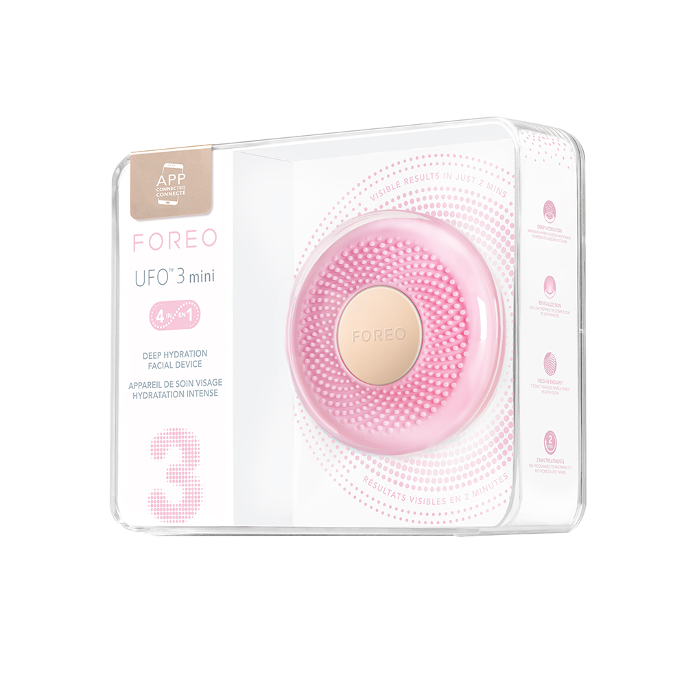 Een roze Foreo UFO 3 mini-apparaat in een doorzichtige plastic doos, met de tekst 'Visible results in just 2 mins'.
