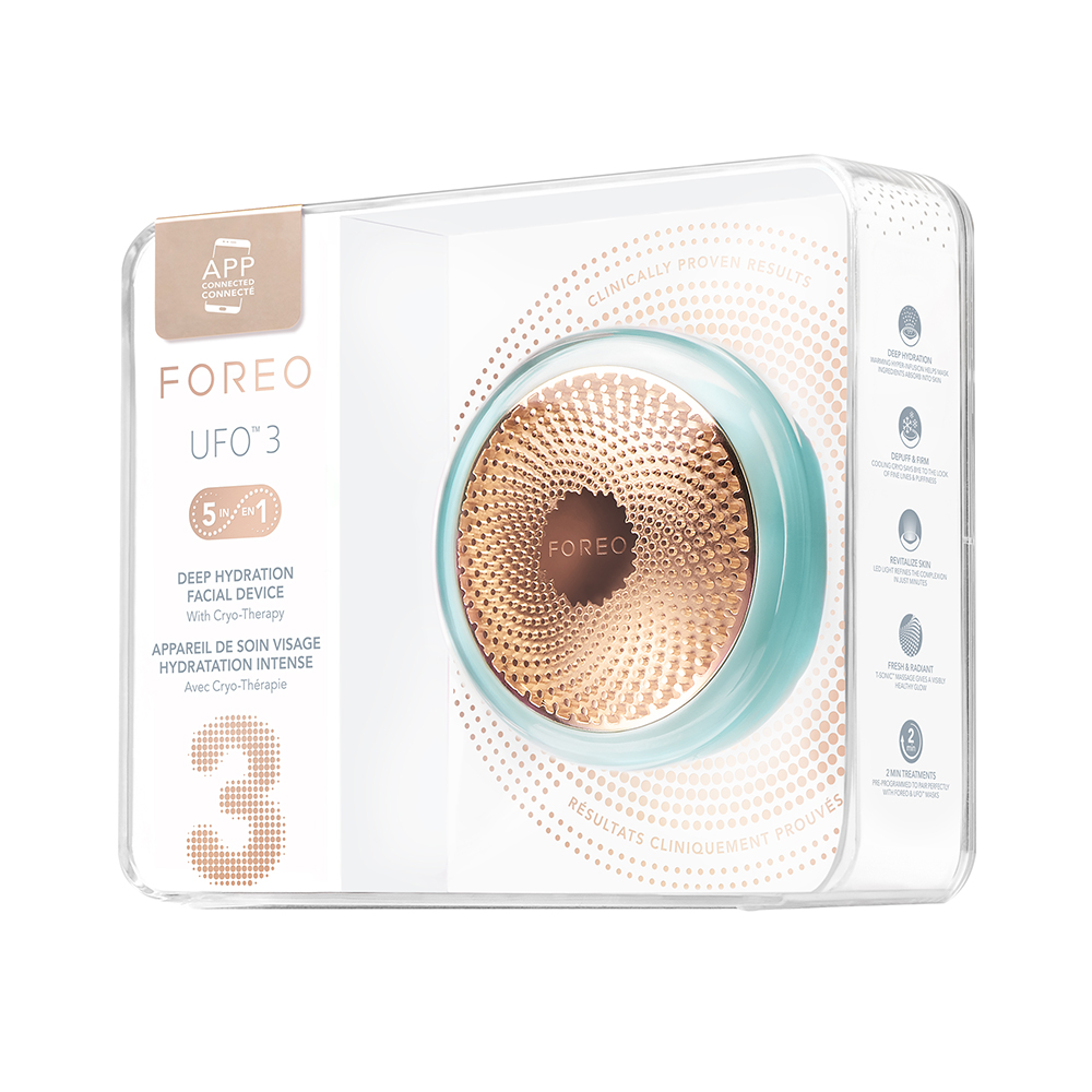 Een turquoise Foreo UFO 3 in een transparante verpakking met labels en informatie. Het apparaat staat centraal.
