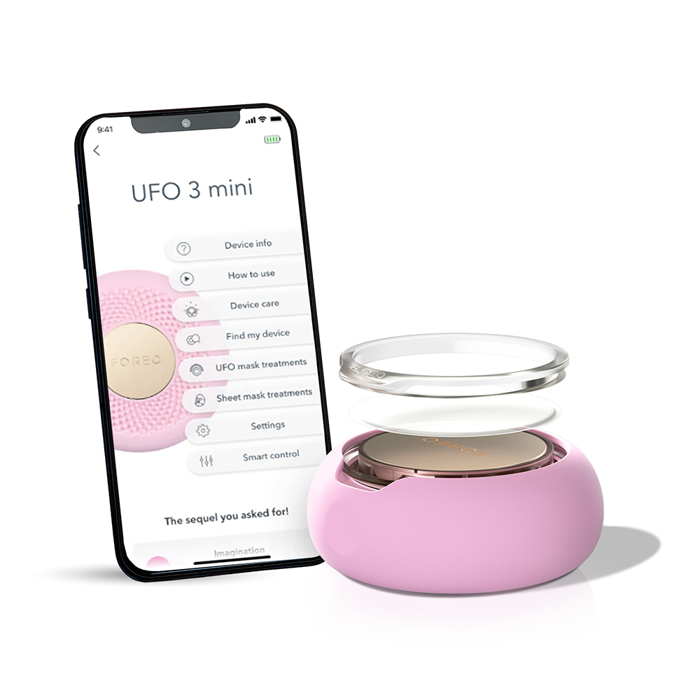 Een smartphone toont een huidverzorgingsapp. Een klein, roze huidverzorgingsapparaat ernaast.