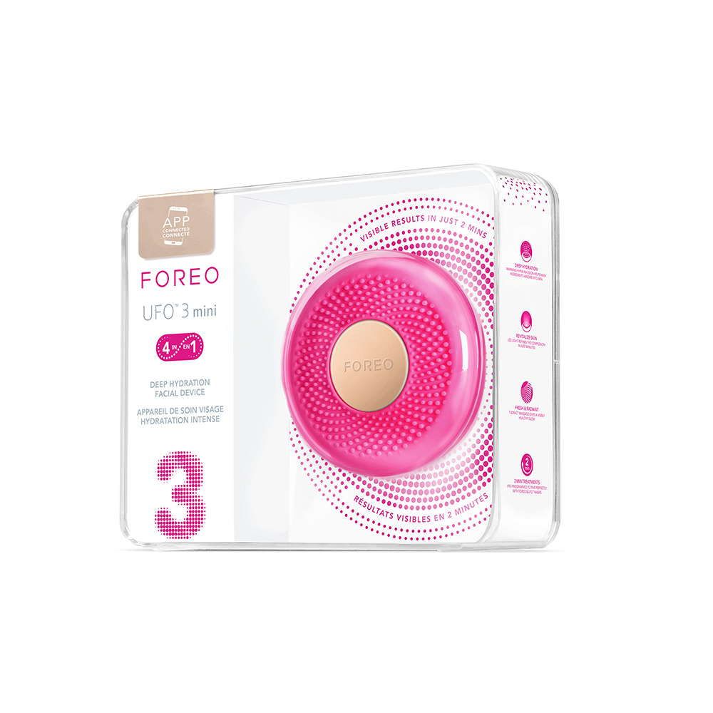Een roze Foreo UFO 3 mini in een transparante doos. De doos heeft informatietiketten.