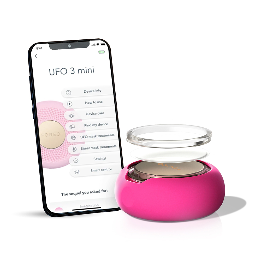 Een telefoon met een Foreo-app naast een roze Foreo UFO 3 mini-apparaat met een witte achtergrond.