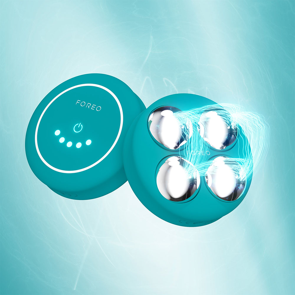 Two teal devices with silver balls are on a blue background. One device is open, showing the inside. Electric lines appear.