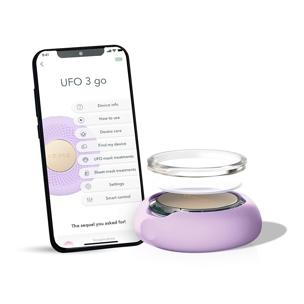 Uygulama özelliklerini gösteren bir telefonun yanında bir Foreo UFO 3 go cihazı.