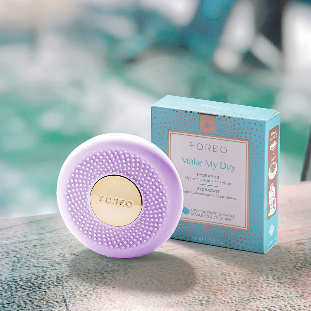 Ahşap bir yüzeyde FOREO cihazı ve Make My Day maske kutusu.