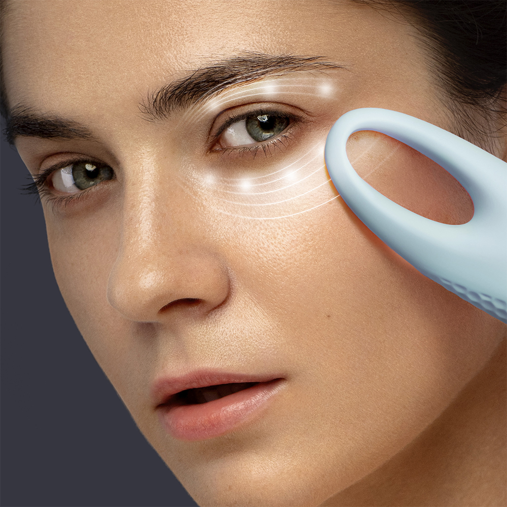 Woman's face with device near eyes. Lines indicate treatment.