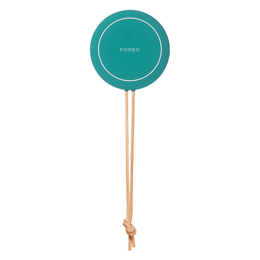 Een turquoise Foreo-apparaat met een beige touw, geplaatst op een wit oppervlak.