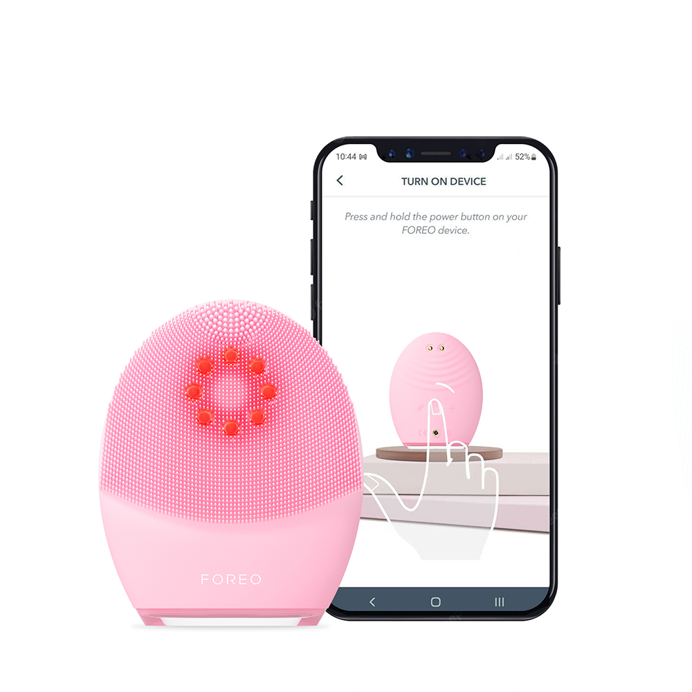 A pink Foreo device and a smartphone displaying instructions.
