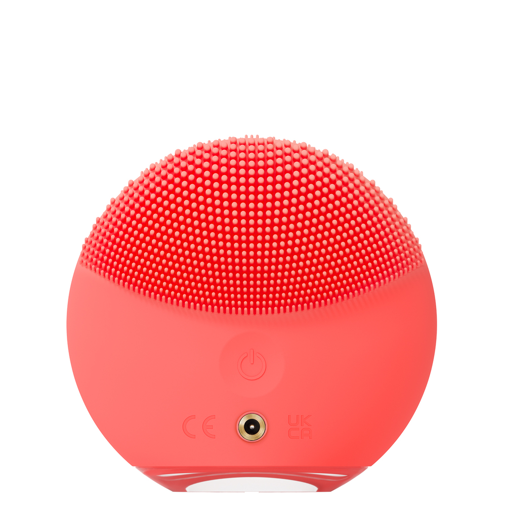 Red, round Foreo device with raised silicone bristles and a power button.